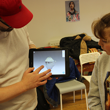 A man shows a girl AR software on a tablet computer