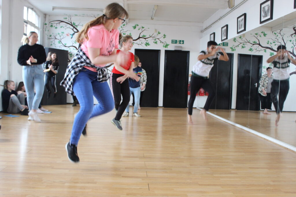 Group of young people jumping or dancing in room